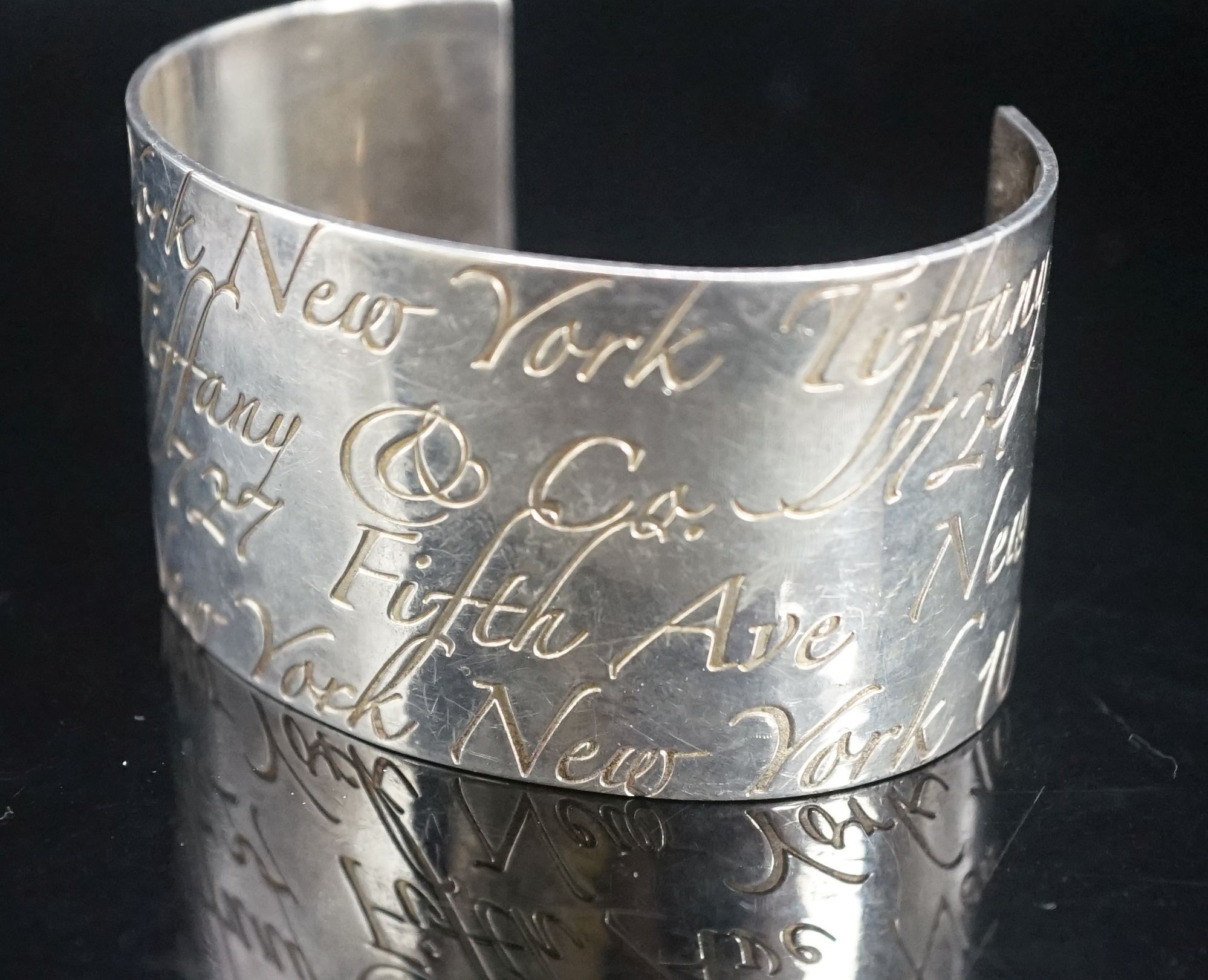 A Tiffany & Co 925 open bangle with engraved script, interior diameter approx. 69mm.